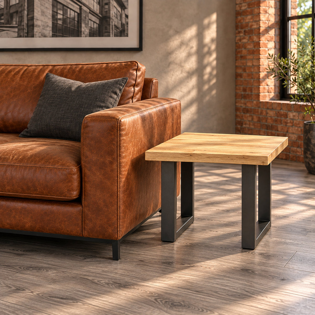 Side-angle view of the Fusion oak lamp table's two rectangular metal loop frames beside a leather sofa.