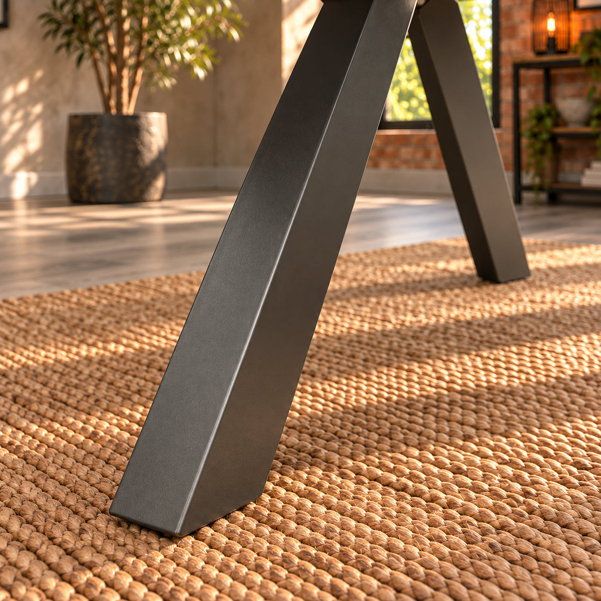 Close-up of an angled charcoal metal leg and foot on the Fusion round dining table.