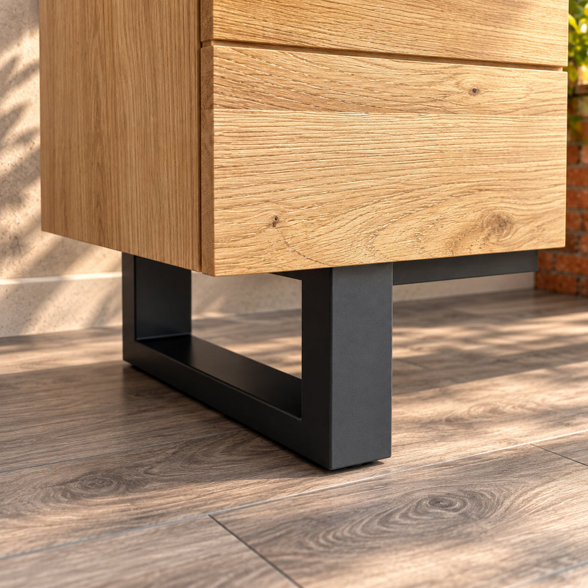 Close-up of the Fusion oak TV unit's charcoal metal loop leg beneath the oak cupboard.