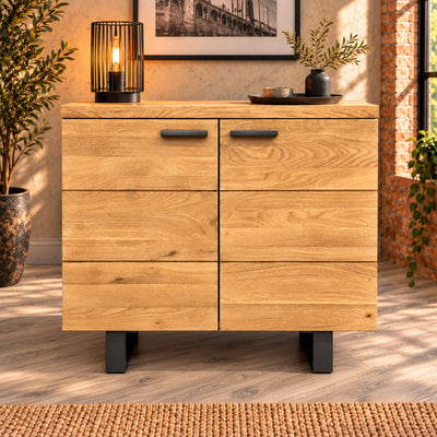 Front view of the compact Fusion Oak 2 Door Sideboard, showing grooved oak doors, dark handles and metal feet.
