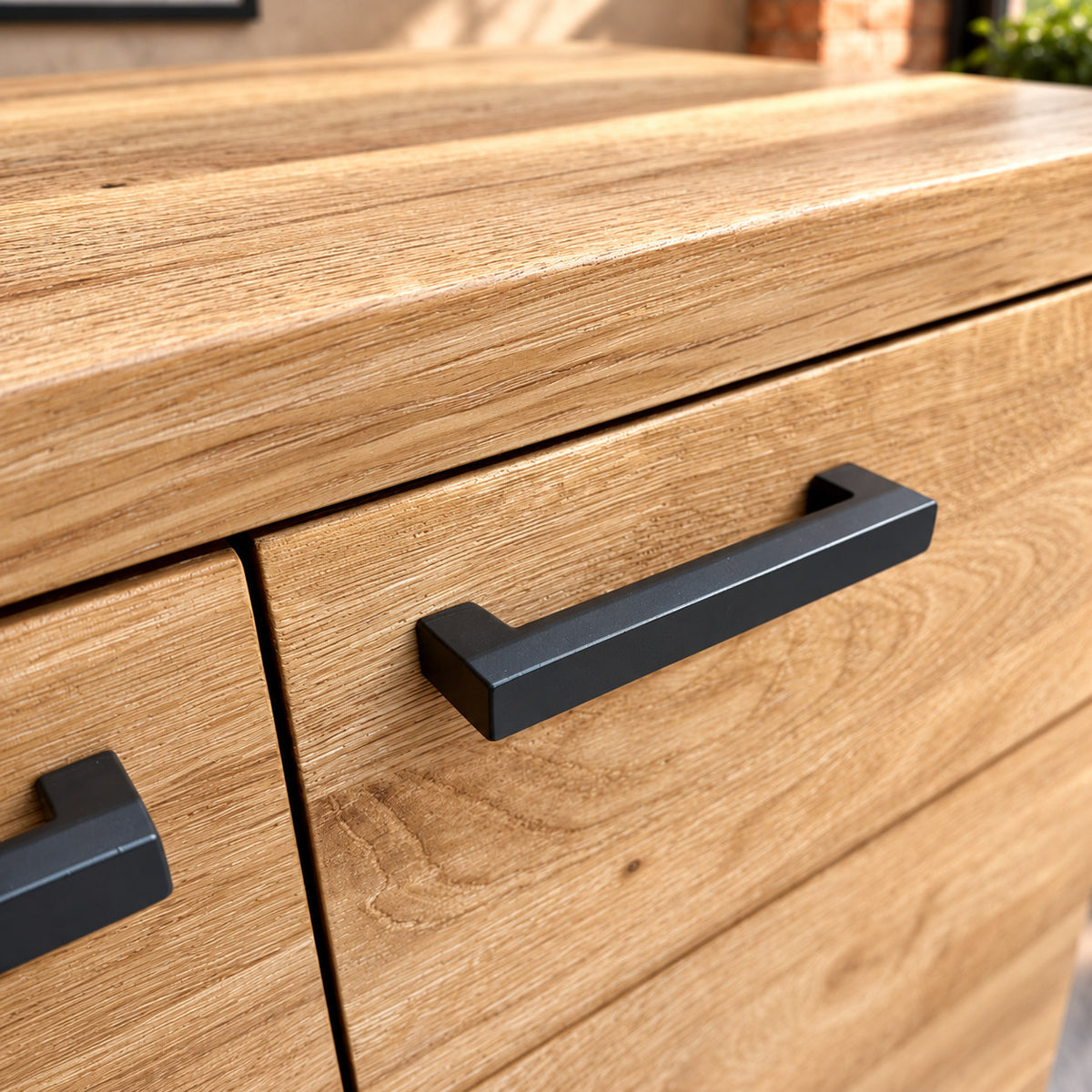 Close-up of the thick oak top edge and paired dark metal handles on the Fusion Oak FS2SB sideboard.