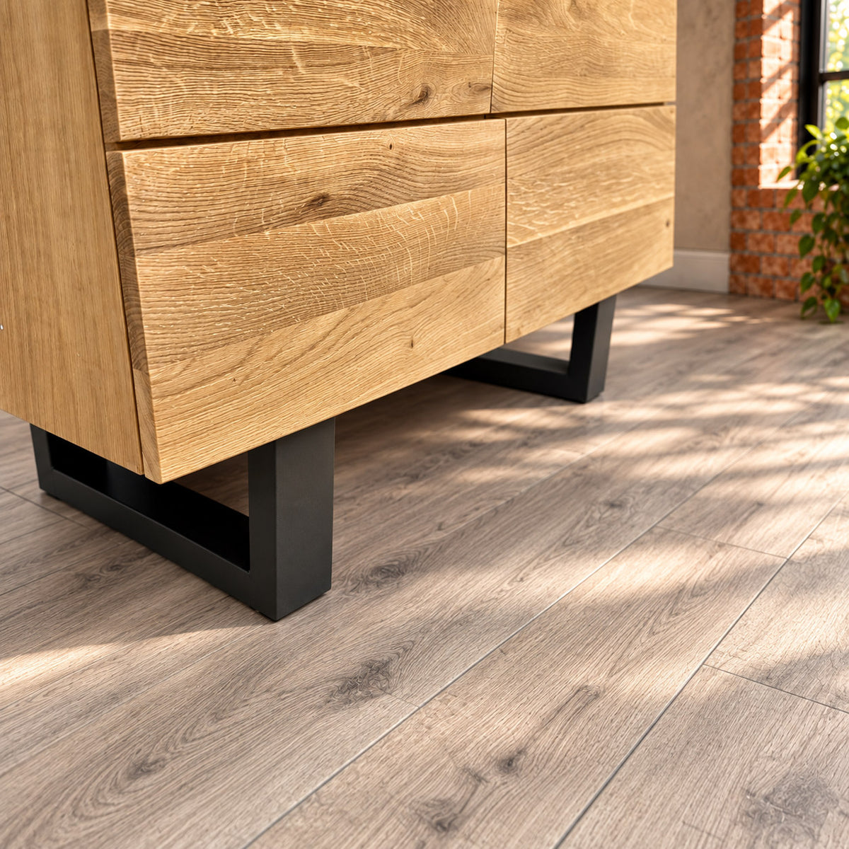 Close-up of the Fusion Oak sideboard’s dark metal loop foot beneath the oak cabinet.
