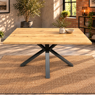 Straight-on view of the Fusion oak compact dining table with its charcoal star-shaped pedestal beneath the oak top.