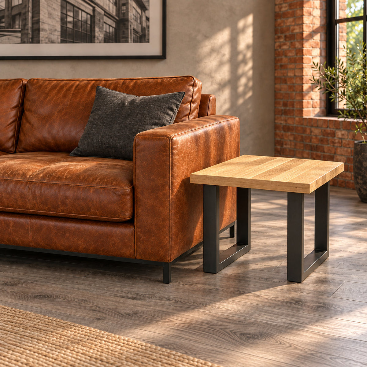 Side-angle view of the Fusion oak lamp table's two rectangular metal loop frames beside a leather sofa.
