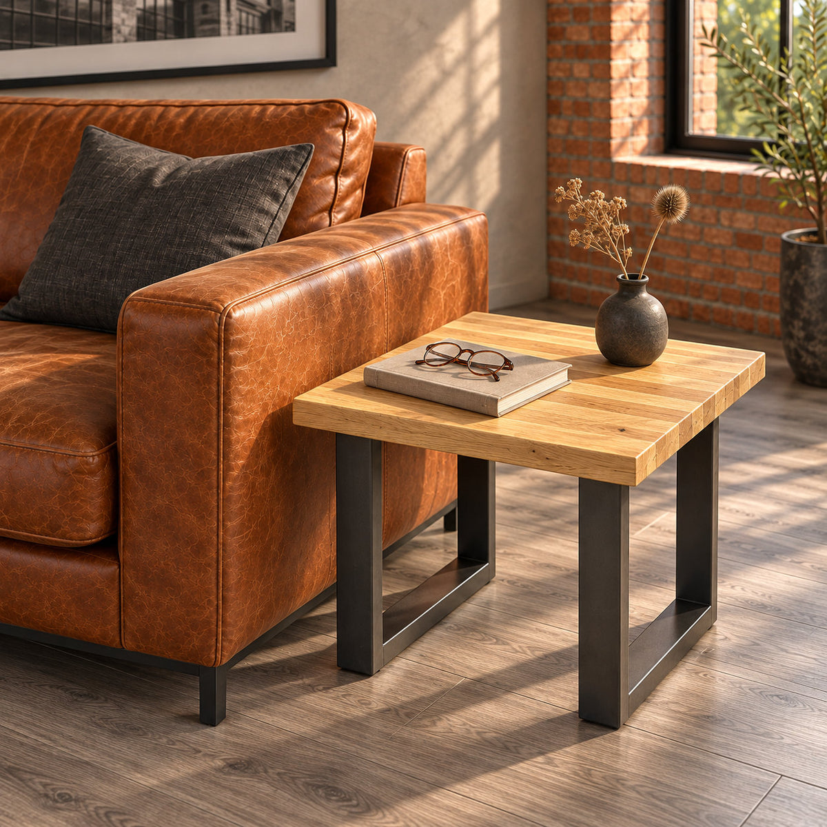 Fusion oak lamp table beside a leather sofa, styled with a small ceramic vase, a book and reading glasses.
