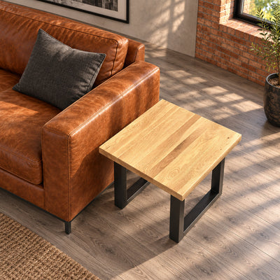 View from above of the Fusion oak lamp table's square top beside the leather sofa, showing natural variation across the oak boards.
