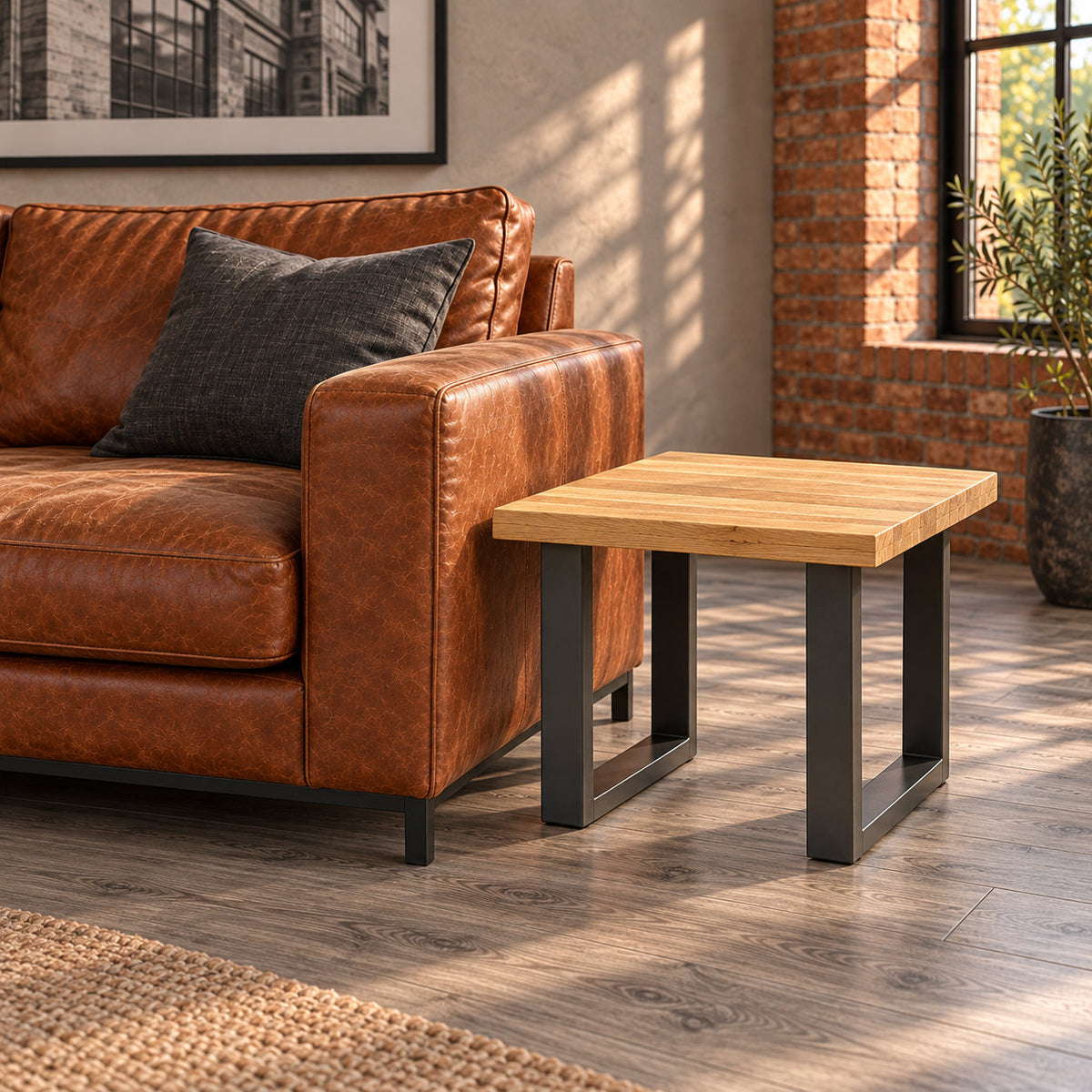 Unstyled Fusion oak lamp table beside a cognac leather sofa, showing the oak surface and both metal loop frames.
