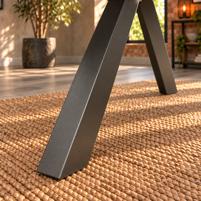 Close-up of an angled charcoal metal leg and foot on the Fusion round dining table.
