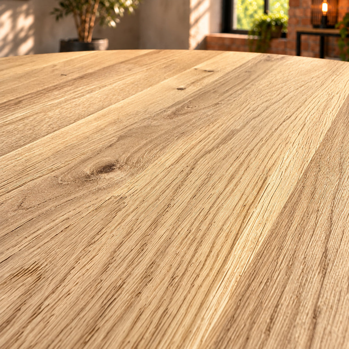 Close-up of the Fusion round dining table's sandblasted oak surface, showing fine grain, shallow texture and natural knots.
